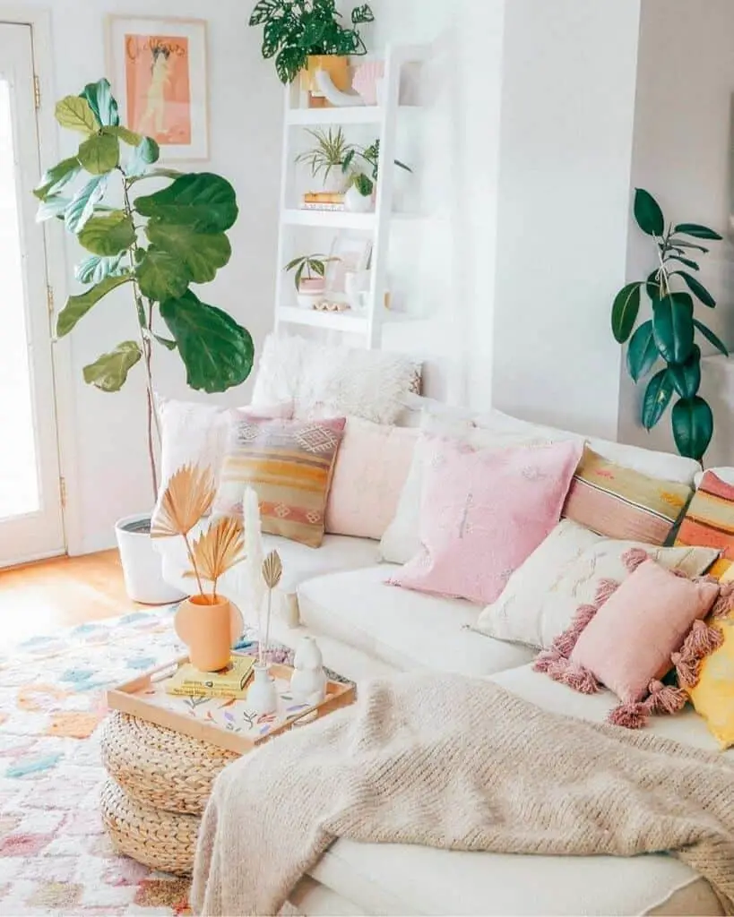 pink yellow and orange pillows on sofa fiddle leaf fig plant in corner