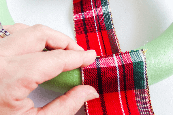 hot glue edge of plaid ribbon to wreath form