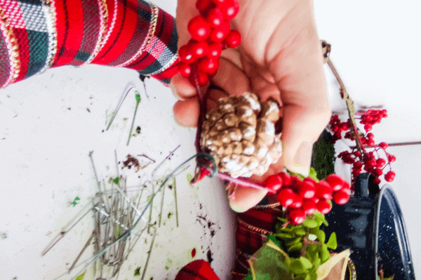 pinecone with fake red berries tied around tip secured with floral wire