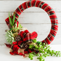 succulents attached to wreath wrapped in red plaid ribbon